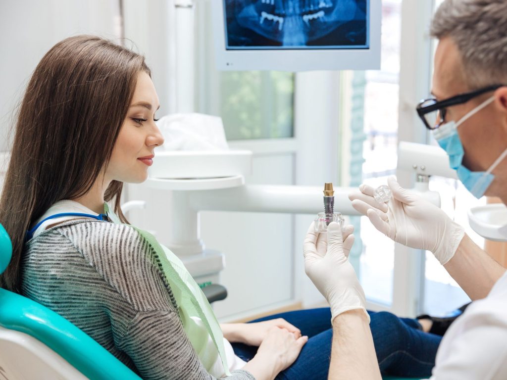 dentist-showing-patient-implant